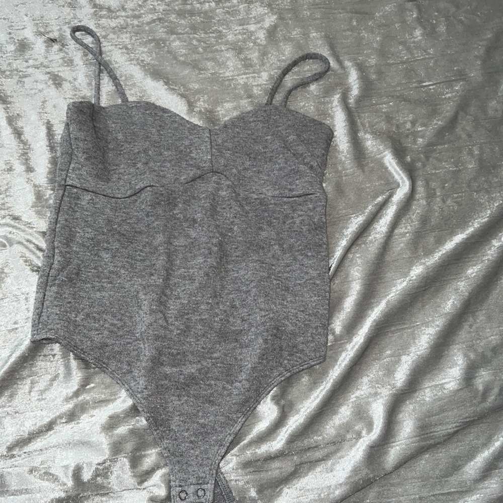 Gray fuzzy body suit with buttons on the bottom
